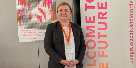 Porträtfoto von Prof. Dr. Liudvika Leišytė. Im Hintergrund Poster des DGS-Kongresses