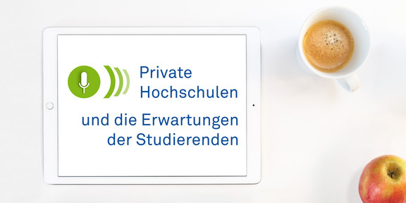 Foto: Ein Tablet Computer, rechts daneben eine Tasse mit Kaffee und ein Apfel