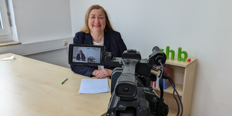 Making-of-Foto bei der Erstellung des Videos über die Professur: Im Vordergrund steht die Videokamera, im Hintergrund ist Prof. Liudvika Leisyte zu sehen