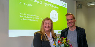 Photo of Prof. Liudvika Leišytė and Prof. Uwe Wilkesmann at the 10th anniversary celebration of the Professorship of Higher Education. Prof. Leišytė holds a bouquet of flowers in her hands.