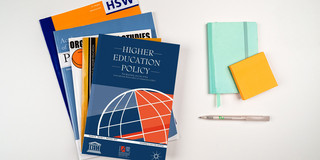 Zeitschriftenstapel, daneben ein Notizbuch und ein Stift