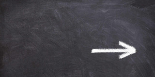 A chalkboard with a white arrow on it