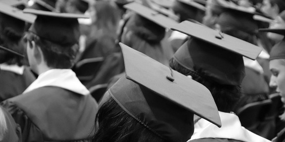 People wearing gowns and graduation hats at a graduation ceremony