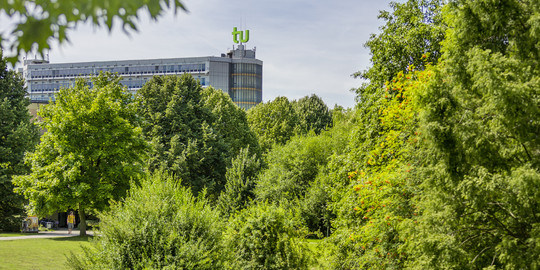 Das Mathematikgebäude mit grünen Bäumen im Vordergrund.